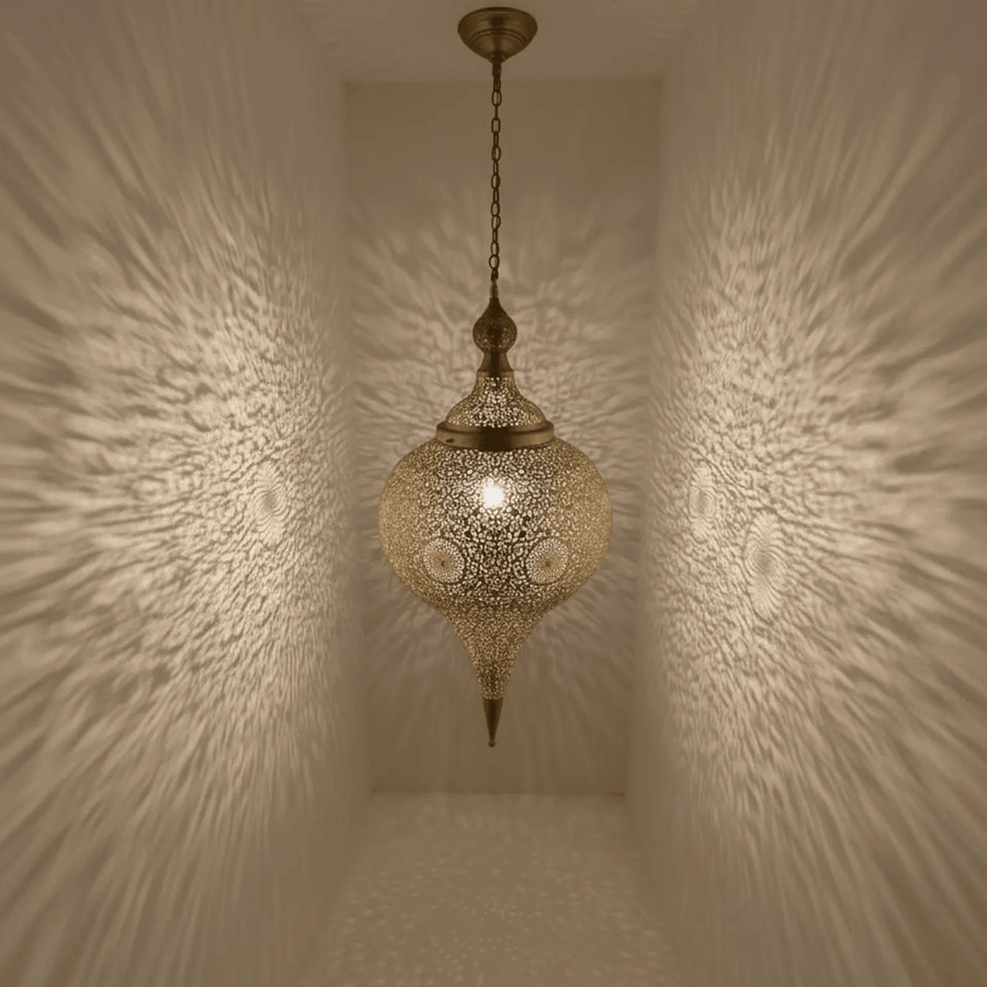 Tall brass teardrop pendant light hanging in boho living room – Brass For Homes