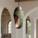 Verdigris copper oval cutout pendant emitting warm patterned light — Brass For Homes